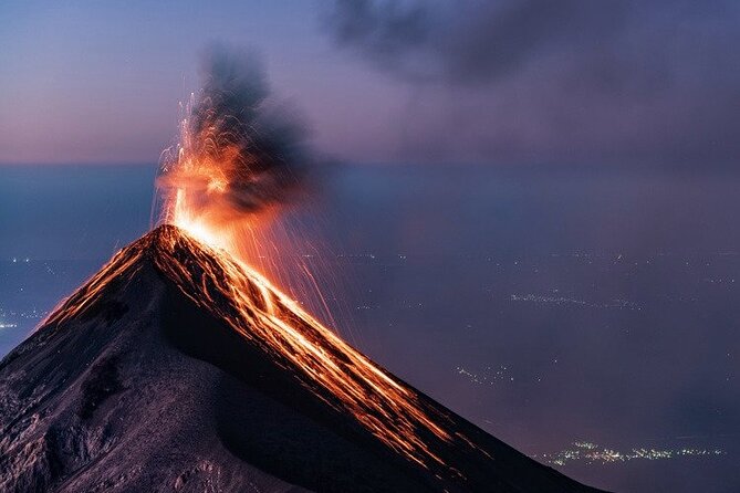 Fuego throwing lava above the Acatenango ridge at dusk